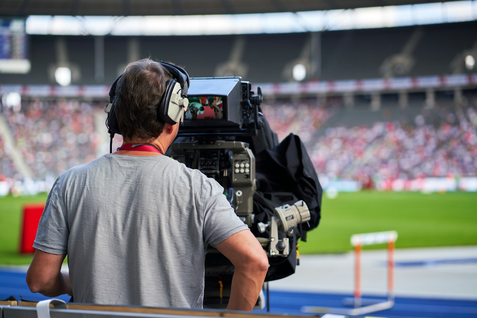 A camera operator filming at a stadium
